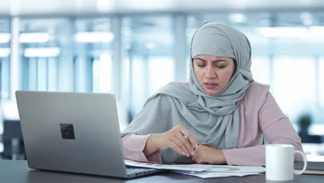 Gestresste-Muslimische-Geschäftsfrau-Liest-Und-Unterschreibt-Dokumente