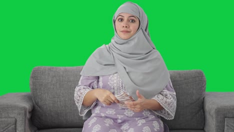 Mujer-Musulmana-Usando-Dinero-Como-Pantalla-Verde-Del-Ventilador.