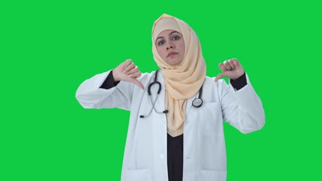 Médico-Musulmán-Decepcionado-Mostrando-Los-Pulgares-Hacia-Abajo-En-La-Pantalla-Verde