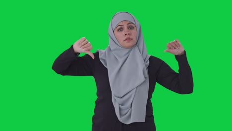 Enttäuschte-Muslimische-Frau-Zeigt-Daumen-Nach-Unten-Auf-Grünem-Bildschirm
