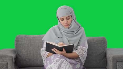 Mujer-Musulmana-Seria-Escribiendo-Un-Diario-Con-Pantalla-Verde