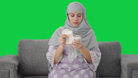 Mujer-Musulmana-Seria-Contando-Dinero-Pantalla-Verde