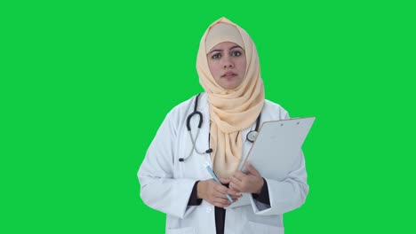Doctor-Musulmán-Serio-Hablando-Con-La-Pantalla-Verde-Del-Paciente
