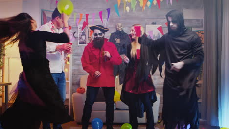Group-of-people-dancing-and-having-fun-at-Halloween-party-in-a-decorated-house
