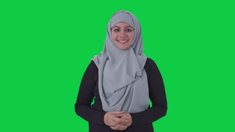 Glückliche-Muslimische-Frau,-Die-Auf-Dem-Grünen-Bildschirm-Der-Kamera-Lächelt