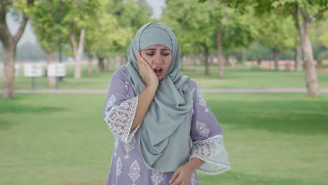Sick-Muslim-woman-suffering-from-Tooth-pain-in-park