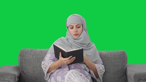 Schläfrige-Muslimische-Frau-Liest-Ein-Buch-Und-Trinkt-Tee-Auf-Grünem-Bildschirm