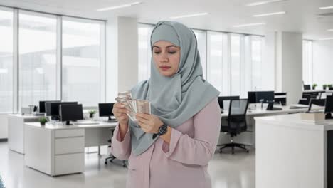 Ernsthafte-Muslimische-Geschäftsfrau,-Die-Geld-Zählt