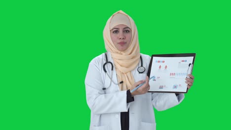 Glücklicher-Muslimischer-Arzt,-Der-Dem-Patienten-Berichte-Auf-Grünem-Bildschirm-Erklärt