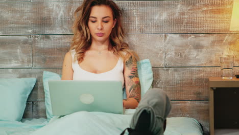 Beautiful-woman-in-pajamas-doing-online-shopping-on-her-laptop