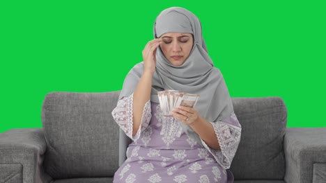 Mujer-Musulmana-Estresada-Contando-Dinero-En-Pantalla-Verde