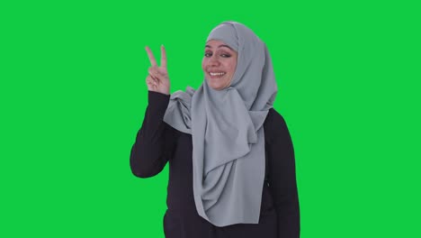 Happy-Muslim-woman-showing-victory-sign-Green-screen