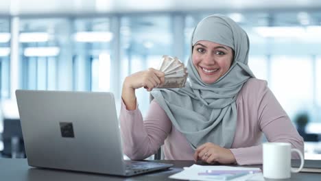 Happy-Muslim-businesswoman-using-money-as-fan