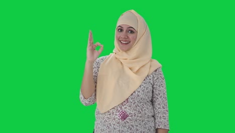 Glücklicher-Muslimischer-Lehrer,-Der-Einen-Grünen-Bildschirm-Mit-Dem-OK-Zeichen-Zeigt