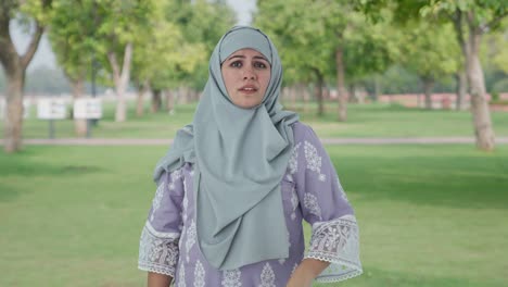 Verärgerte-Muslimische-Frau,-Die-Eine-Biene-Im-Park-Fliegt