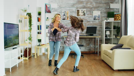 Cheerful-mother-and-daughter-dancing-in-living-room