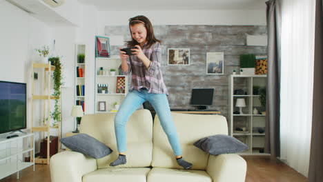 Little-girl-jumping-on-the-couch-in-living-room