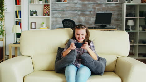 Aufgeregtes-Kleines-Mädchen,-Das-Videospiele-Auf-Ihrem-Handy-Spielt
