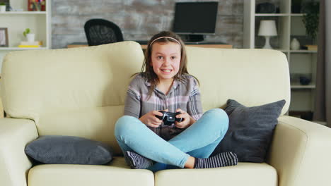 Cheerful-little-girl-playing-video-games-using-wireless-controller