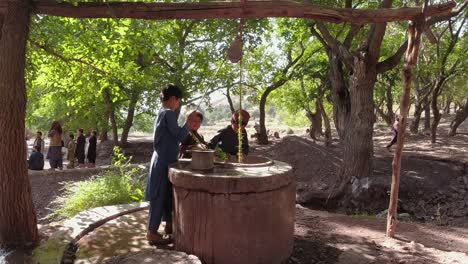 A-child-scooping-water-up-with-their-hands-from-a-well