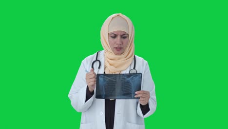 Muslimischer-Arzt-überprüft-Röntgenbericht-Auf-Grünem-Bildschirm