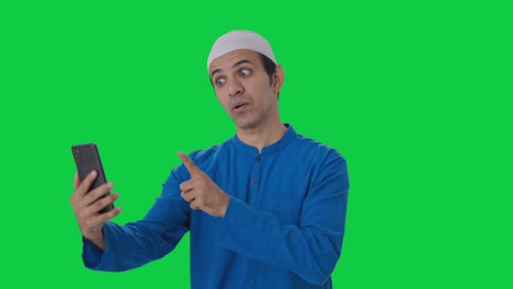 Angry-Muslim-man-shouting-on-video-call-using-phone-Green-screen