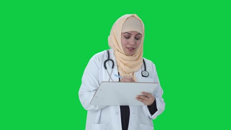 Feliz-Médico-Musulmán-Escribiendo-Medicamentos-Para-La-Pantalla-Verde-Del-Paciente