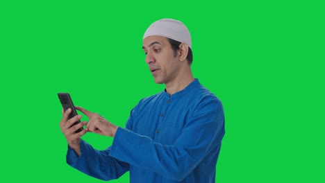 Sleepy-Muslim-man-using-Phone-Green-screen