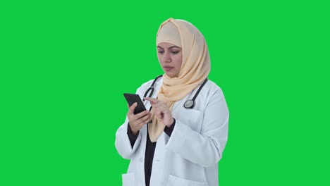 Médico-Musulmán-Usando-Una-Pantalla-Verde-De-Teléfono