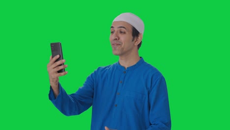 Glücklicher-Muslimischer-Mann,-Der-Auf-Einem-Videoanruf-Mit-Grünem-Bildschirm-Spricht