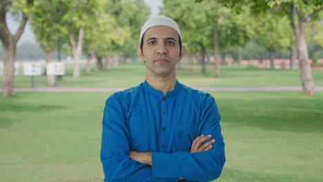 Confident-Muslim-man-standing-crossed-hands-in-park