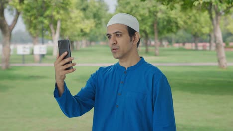 Hombre-Musulmán-Hablando-Por-Videollamada-En-El-Parque
