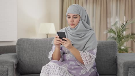 Mujer-Musulmana-Enviando-Mensajes-A-Alguien-Por-Teléfono