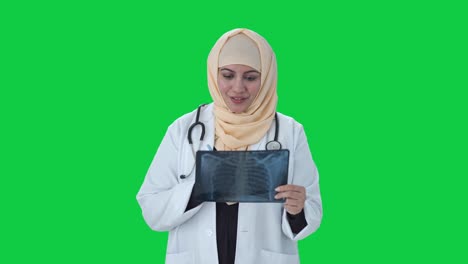 Glücklicher-Muslimischer-Arzt,-Der-Röntgenaufnahmen-überprüft-Und-Grünen-Bildschirm-Diagnostiziert