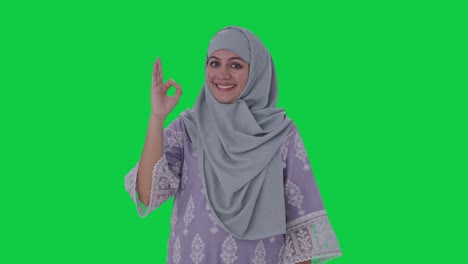 Fröhliche-Muslimische-Frau,-Die-Ein-Okay-Zeichen-Auf-Grünem-Bildschirm-Zeigt