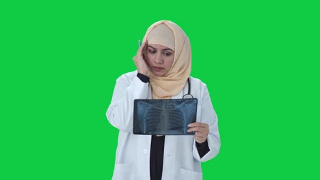 Médico-Musulmán-Estresado-Revisando-La-Pantalla-Verde-Del-Informe-De-Rayos-X