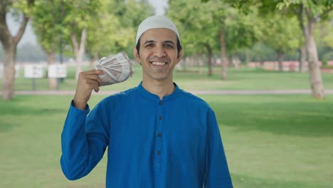 Glücklicher-Muslimischer-Mann,-Der-Geld-Als-Fächer-Im-Park-Verwendet