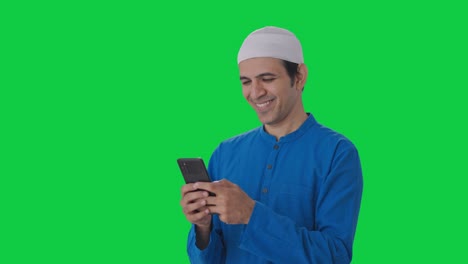 Glücklicher-Muslimischer-Mann,-Der-Auf-Dem-Grünen-Bildschirm-Des-Telefons-Chattet