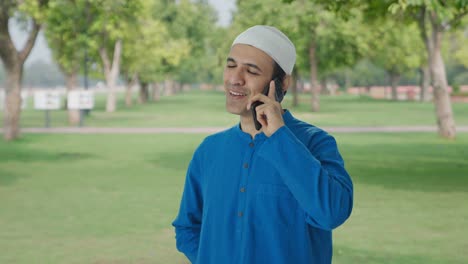 Hombre-Musulmán-Feliz-Hablando-Por-Teléfono-En-El-Parque