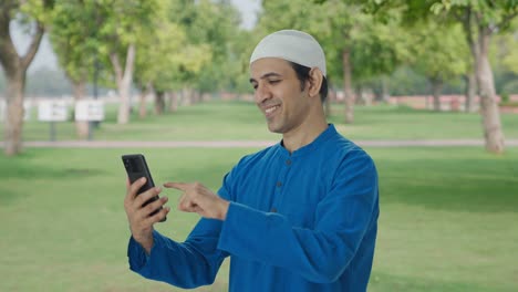 Hombre-Musulmán-Feliz-Usando-El-Teléfono-En-El-Parque