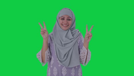 Happy-Muslim-woman-showing-victory-sign-Green-screen