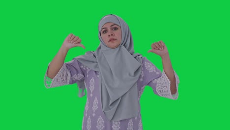 Mujer-Musulmana-Decepcionada-Mostrando-Los-Pulgares-Hacia-Abajo-En-La-Pantalla-Verde