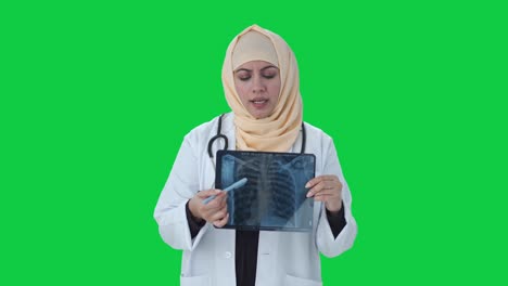 Médico-Musulmán-Revisando-El-Informe-De-Rayos-X-A-La-Pantalla-Verde-Del-Paciente.