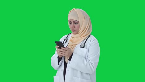 Médico-Musulmán-Enviando-Mensajes-A-Alguien-En-La-Pantalla-Verde-Del-Teléfono