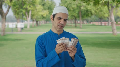 Trauriger-Muslimischer-Mann,-Der-Im-Park-Geld-Zählt