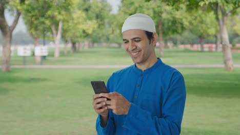 Glücklicher-Muslimischer-Mann,-Der-Im-Park-Telefoniert