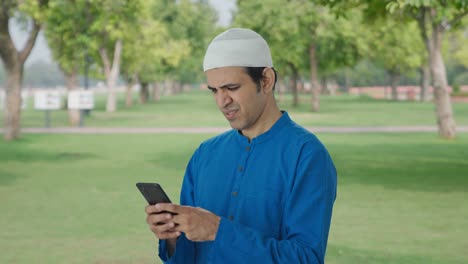 Angry-Muslim-man-chatting-on-phone-in-park