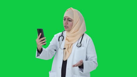 Médico-Musulmán-Enojado-Hablando-En-Videollamada-En-Pantalla-Verde