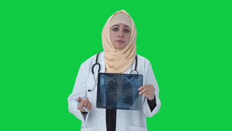 Stressed-Muslim-doctor-checking-X-ray-report-to-patient-Green-screen