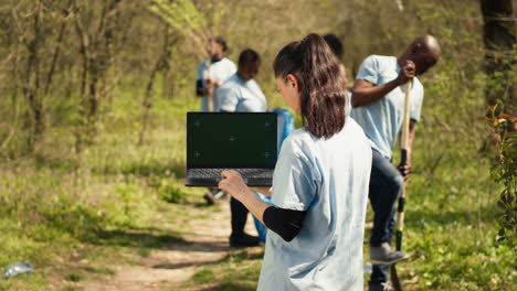 Environmental-conservation-volunteer-holds-a-greenscreen-laptop